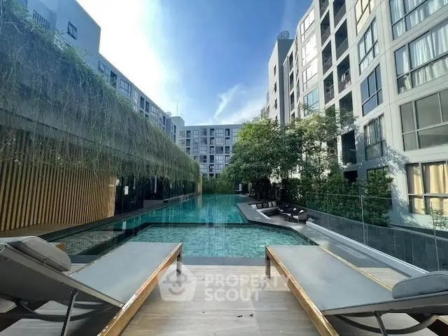 Luxurious apartment complex with stunning pool and modern architecture.