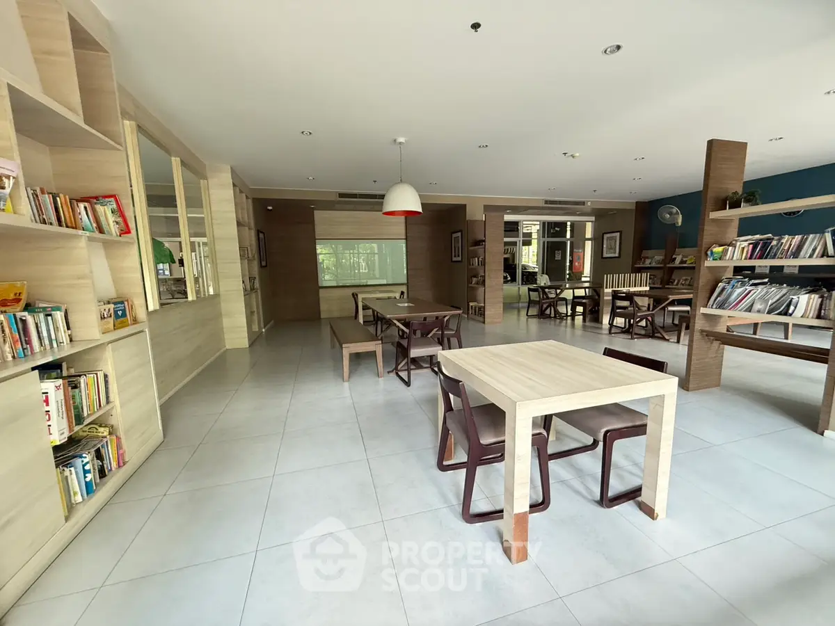 Spacious library with modern wooden shelves and ample seating in a serene setting.