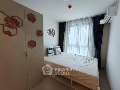 Modern bedroom with stylish decor and natural light, featuring a comfortable bed and air conditioning.