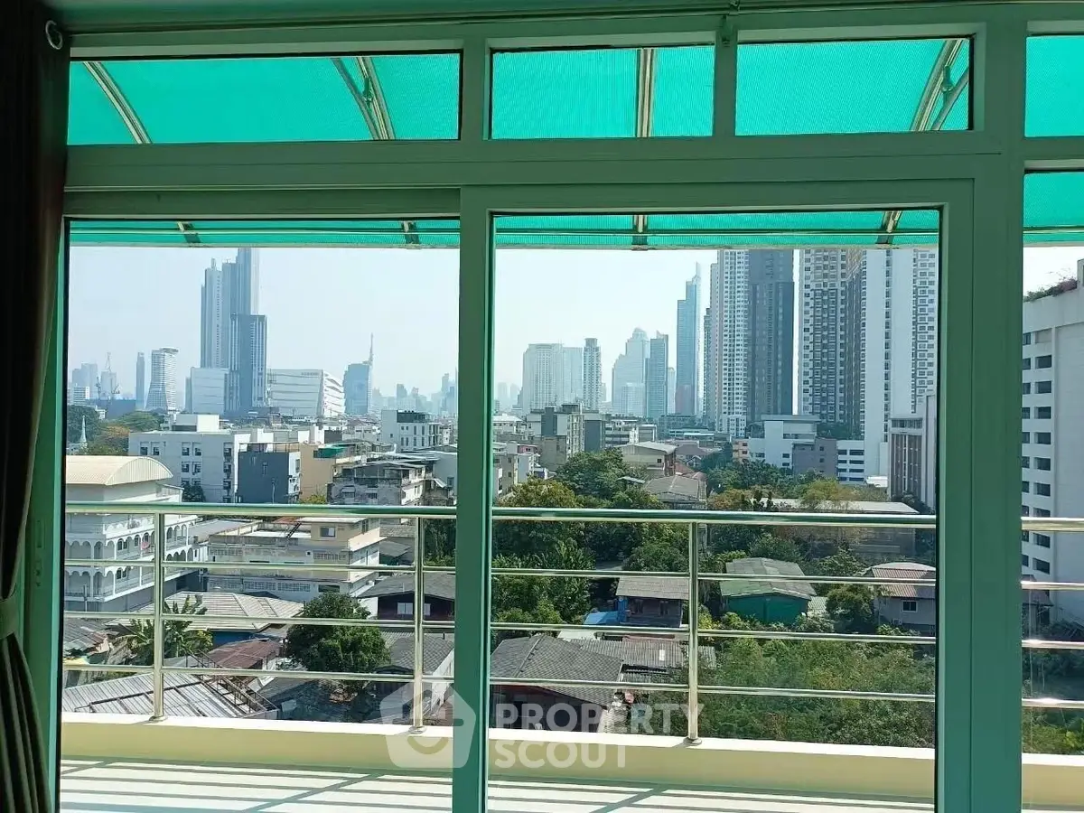 Stunning cityscape view from a modern balcony with glass railing, perfect for urban living.