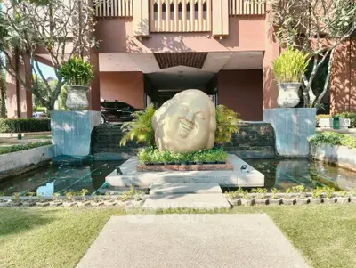 Elegant entrance with serene sculpture and lush landscaping