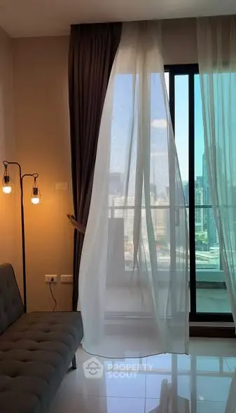 Modern living room with floor-to-ceiling windows and city view, featuring stylish lighting and elegant curtains.