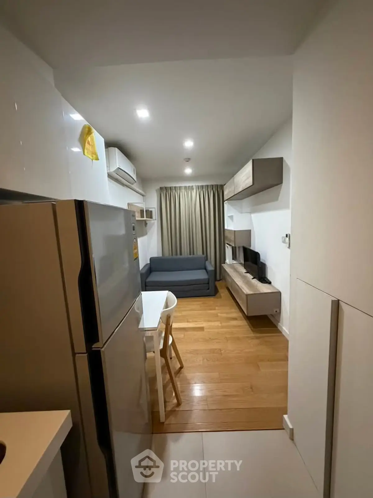 Modern compact living room with sleek furniture and wooden flooring