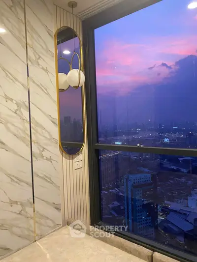 Luxurious high-rise apartment with stunning city view at sunset, featuring elegant marble accents and modern lighting.
