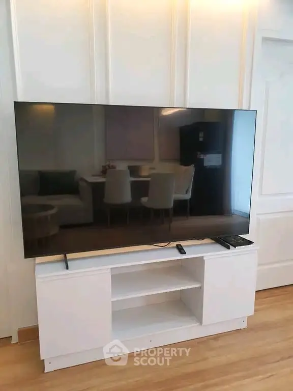 Modern living room with sleek TV setup and elegant dining area