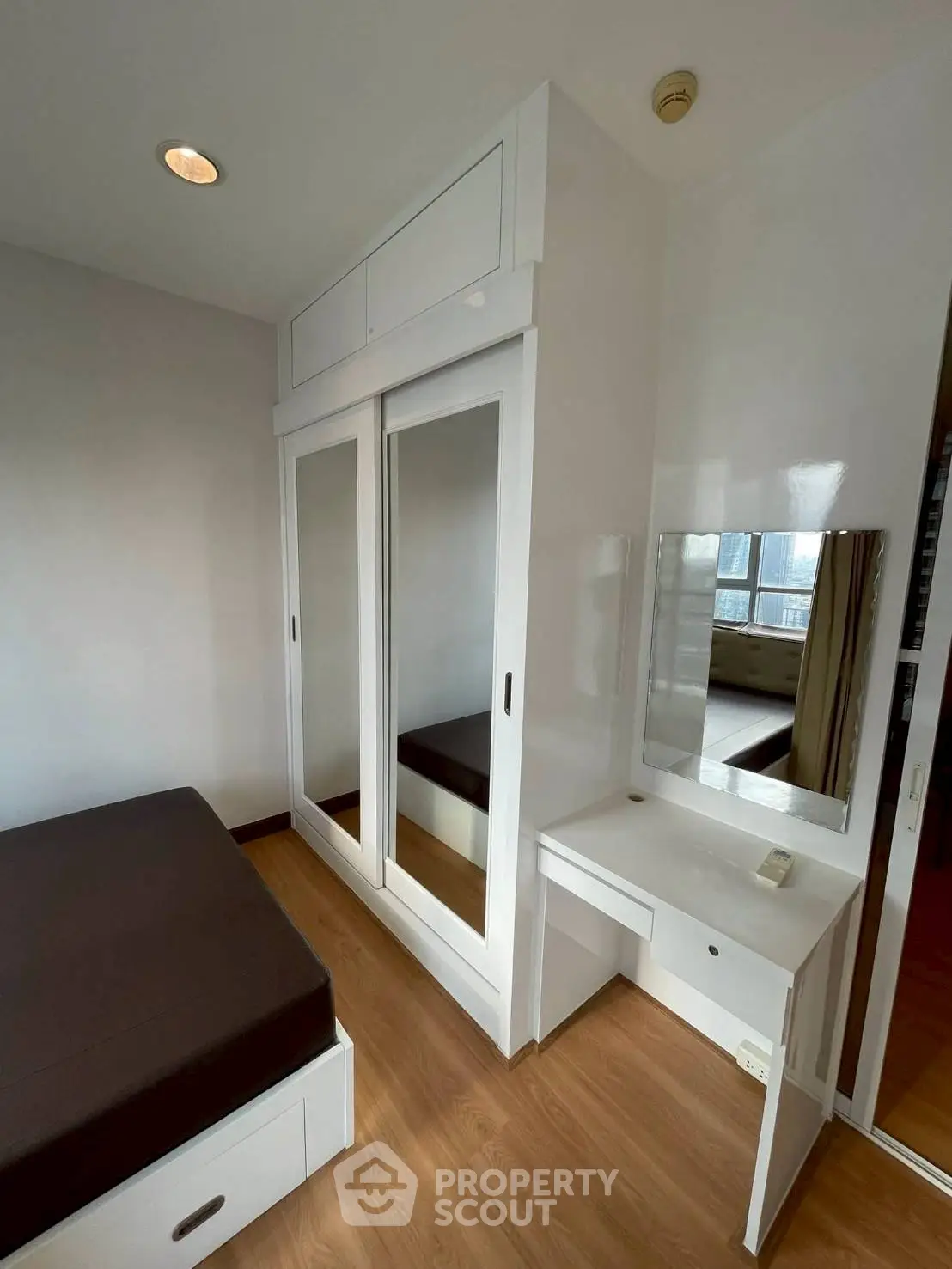 Modern bedroom with built-in wardrobe and vanity in a cozy apartment
