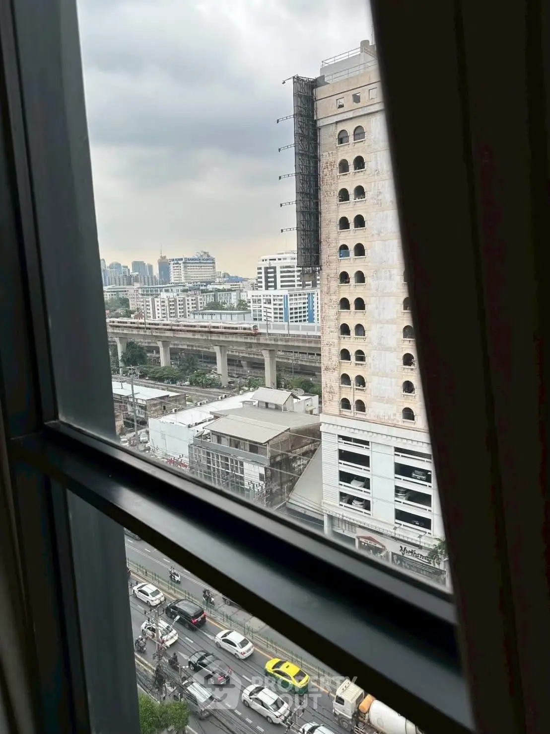 Urban cityscape view from window with busy street and high-rise buildings.