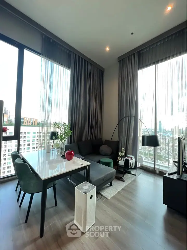 Modern living room with city view, stylish furniture, and floor-to-ceiling windows