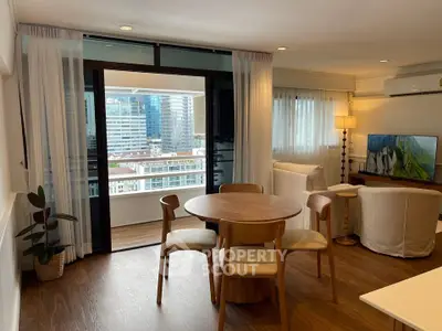 Spacious living room with balcony and city view, featuring modern furniture and elegant decor.