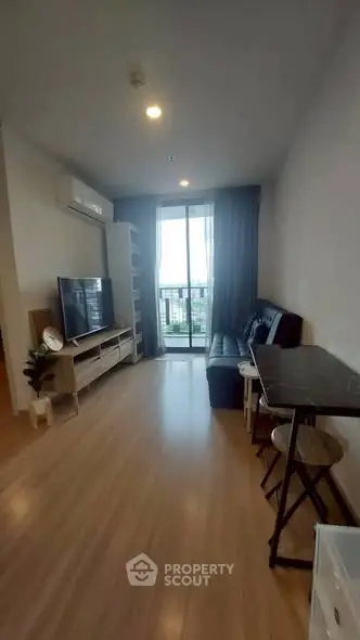 Modern living room with balcony view, sleek furniture, and natural light.