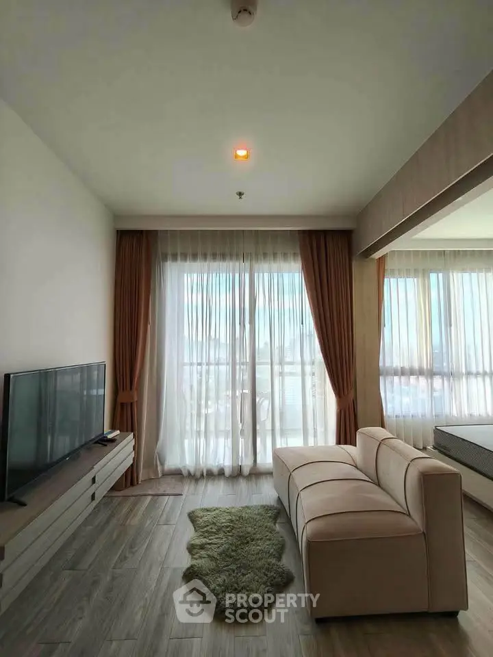 Modern living room with large windows and stylish furniture, offering a bright and inviting atmosphere.