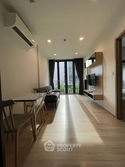 Modern living room with sleek furniture and large windows offering natural light.