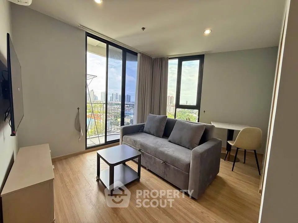 Modern living room with city view, featuring a cozy sofa and sleek decor, perfect for urban living.