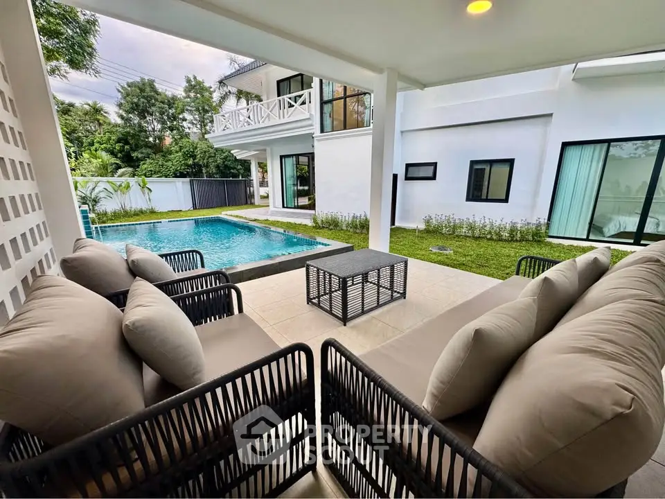 Luxurious modern home with poolside patio and elegant outdoor seating area.