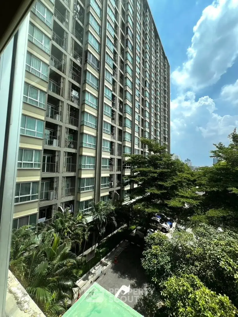 Stunning high-rise building with lush greenery and clear blue sky view.