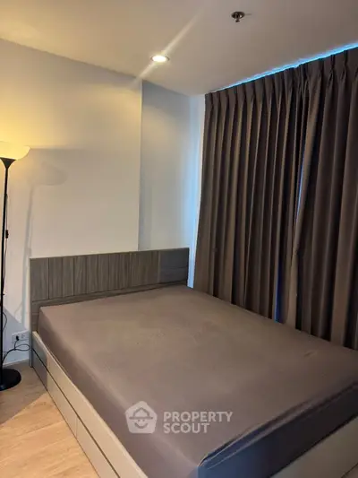 Cozy bedroom with modern design and soft lighting, featuring a comfortable bed and elegant curtains.