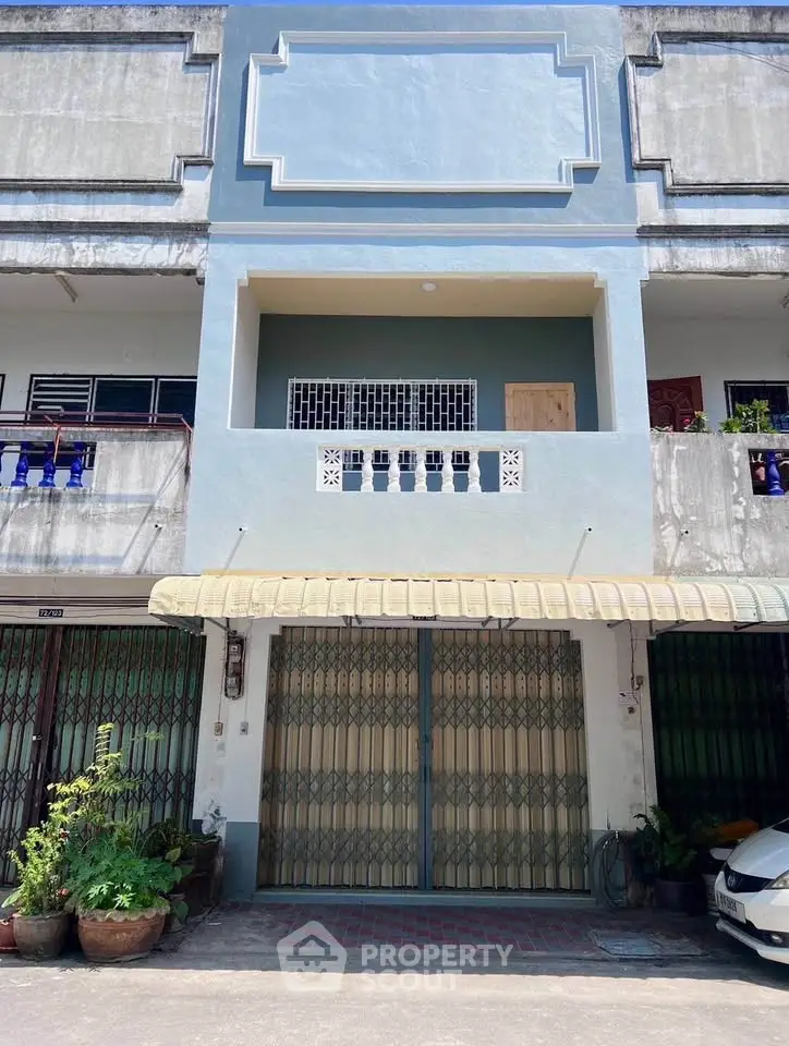 Charming townhouse with a balcony and gated entrance, perfect for urban living.