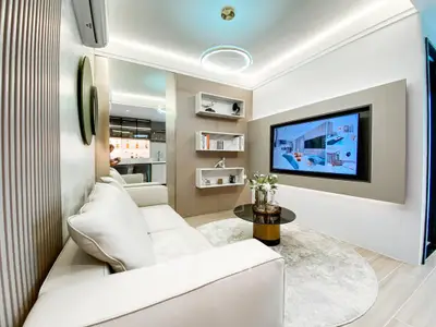 Modern living room with sleek design, featuring a large TV, elegant lighting, and comfortable seating.