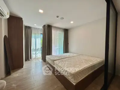 Spacious bedroom with twin beds and large window offering natural light.