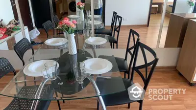 Modern dining area with glass table and elegant chairs in a stylish apartment.