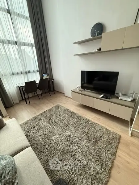 Modern living room with high ceilings, sleek furniture, and large windows for natural light.