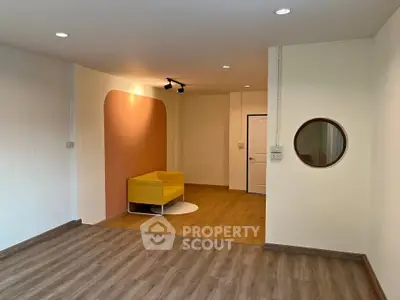 Modern living room with stylish yellow chair and wooden flooring