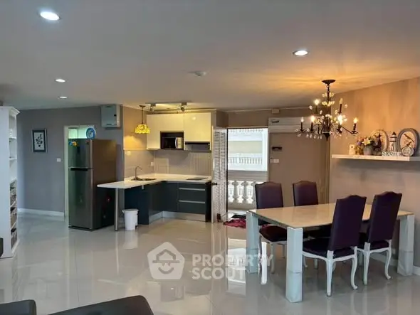 Spacious open-plan kitchen and dining area with modern appliances and elegant lighting.