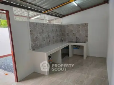 Modern kitchen with tiled backsplash and open layout in a bright space.