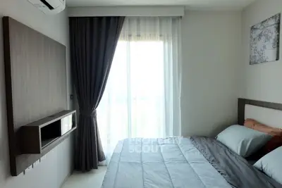 Modern bedroom with sleek design and natural light through large window.