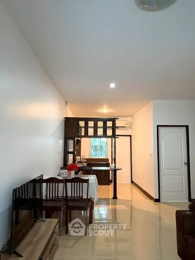 Spacious open-plan living and dining area with modern kitchen in a cozy apartment.