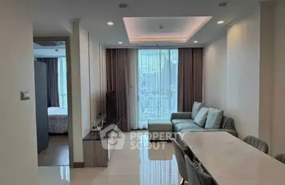 Modern living room with city view, featuring sleek furniture and elegant dining area.