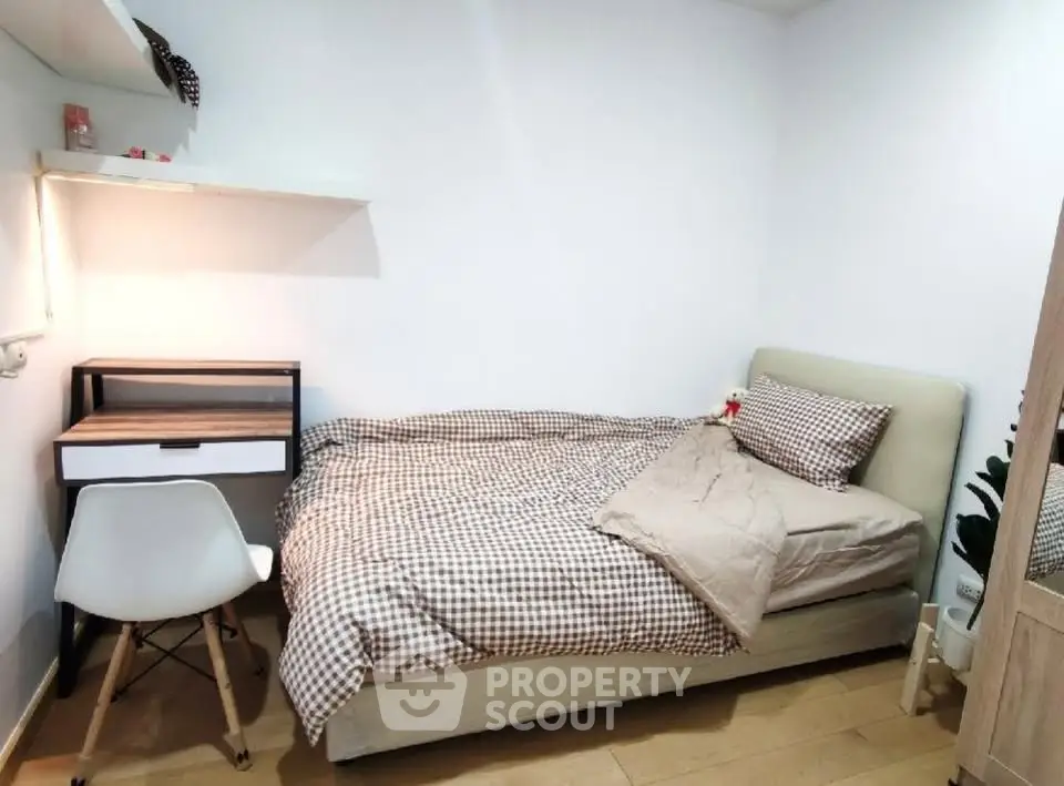 Cozy bedroom with modern desk and comfortable bed in stylish apartment.