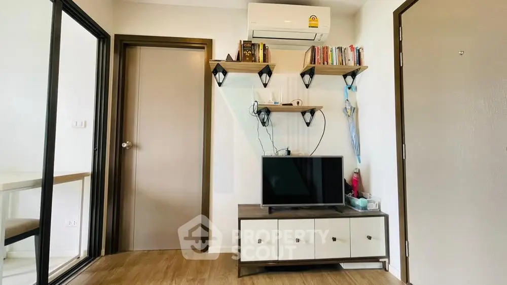 Modern living room with air conditioning, TV, and stylish shelving in a cozy apartment.