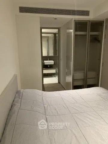Modern bedroom with ensuite bathroom and sleek wardrobe design.