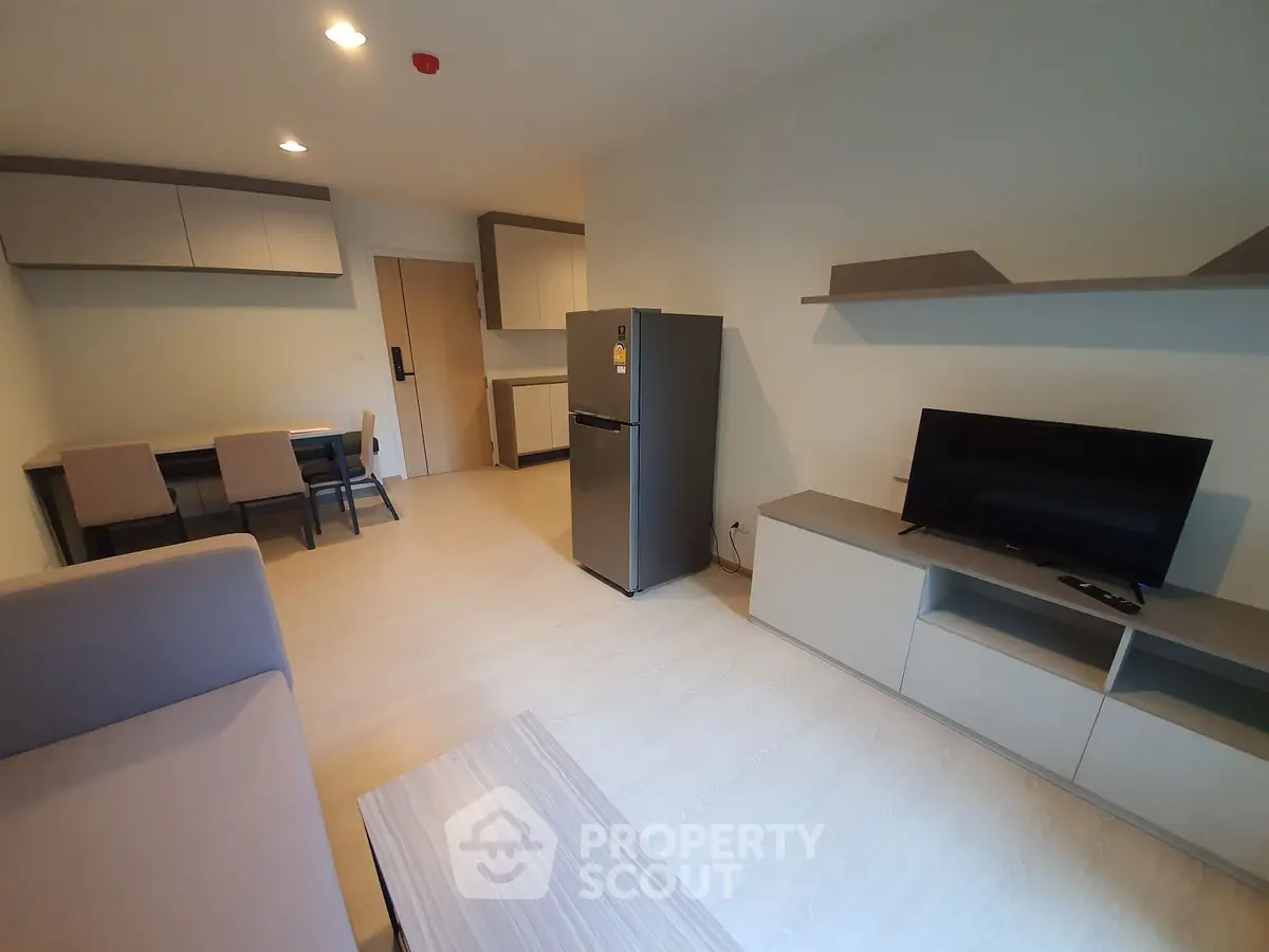 Modern living room with sleek furniture and appliances in a stylish apartment.