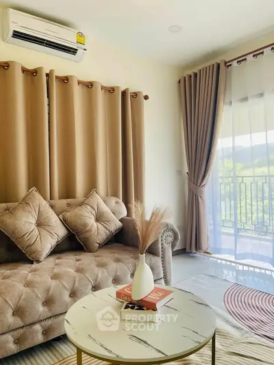 Stylish living room with plush sofa, elegant curtains, and scenic balcony view.