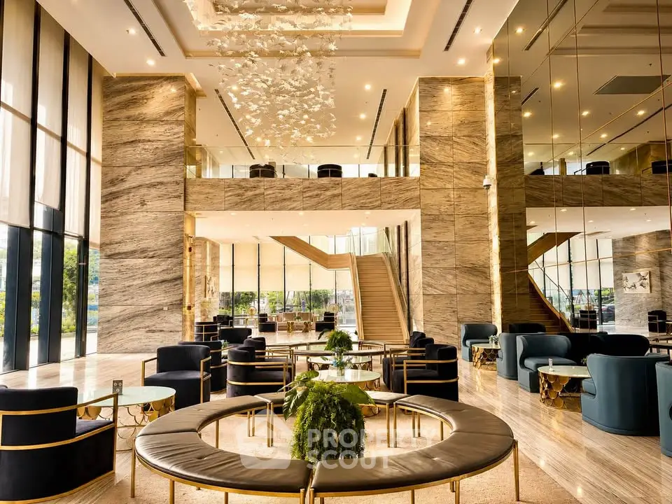 Luxurious hotel lobby with elegant seating and grand staircase, featuring modern design and natural light.