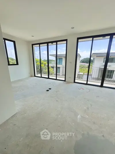 Spacious room with large windows and balcony view in modern home