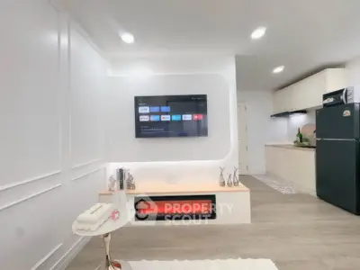 Modern living room with wall-mounted TV and sleek kitchen area