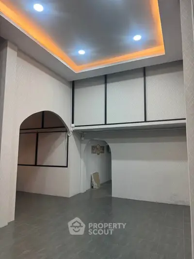 Spacious modern interior with high ceilings and elegant lighting, perfect for versatile living or office space.