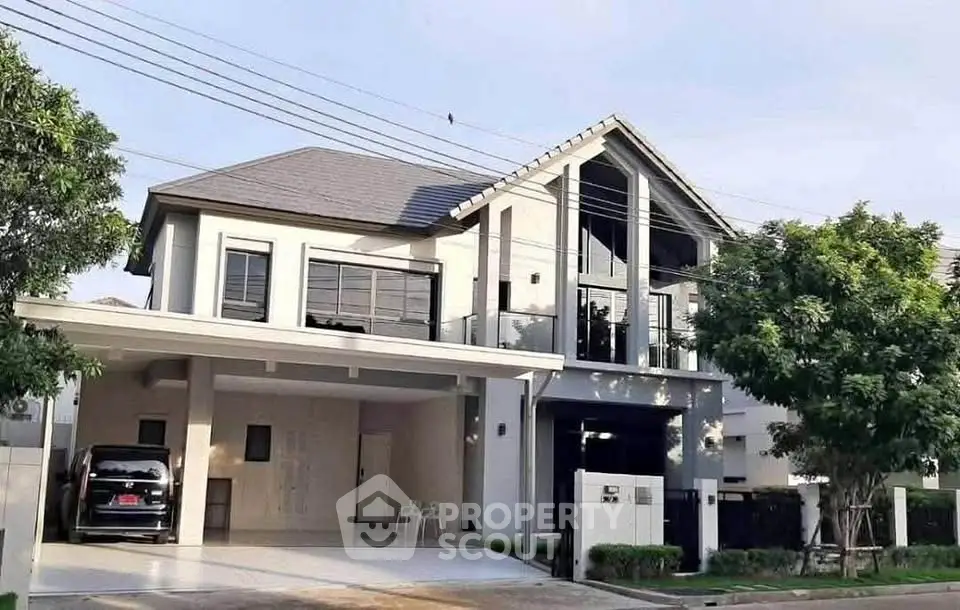 Modern two-story house with spacious driveway and lush greenery