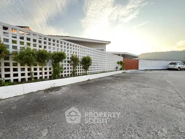 Spacious parking area with modern lattice fence and scenic view.