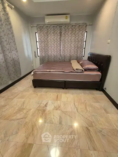 Spacious bedroom with elegant flooring and cozy bed setup