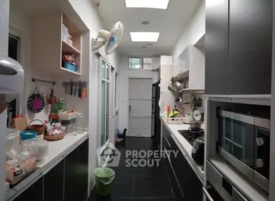 Modern kitchen with sleek cabinetry and appliances in a narrow layout.