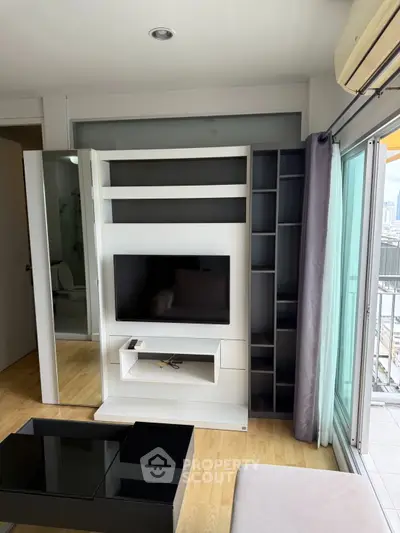 Modern living room with sleek TV stand and city view balcony