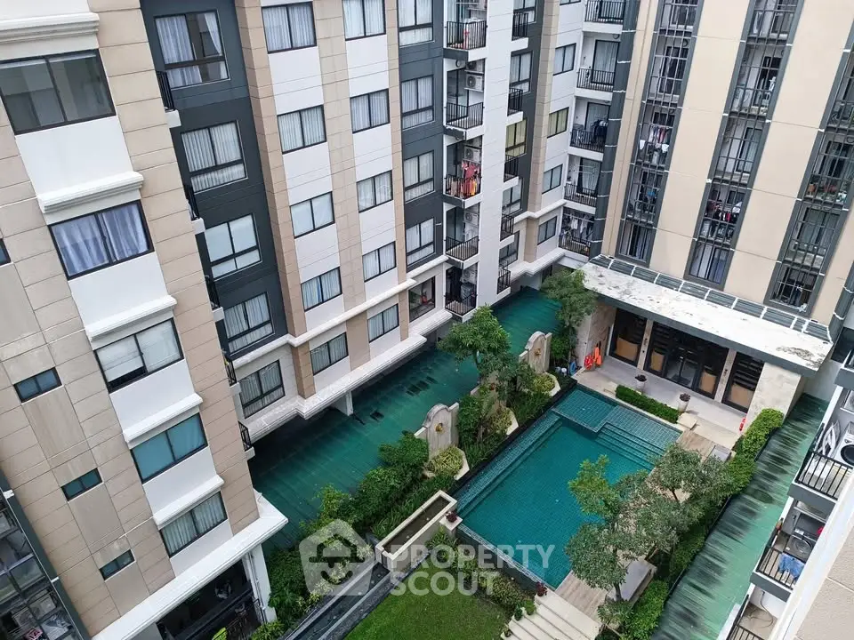 Modern apartment complex with a central swimming pool and lush greenery, offering a serene urban living experience.