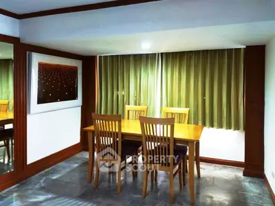 Charming dining area with wooden table and chairs, complemented by elegant green curtains and modern decor.