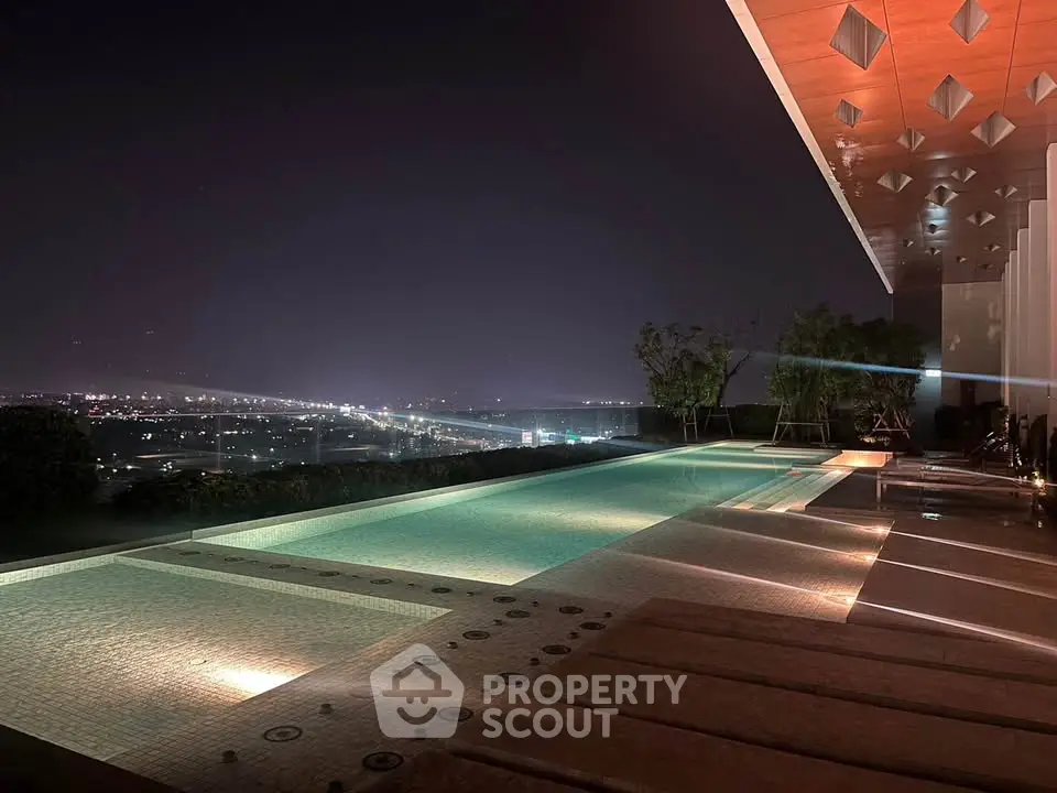 Luxurious rooftop pool with stunning night city view, perfect for relaxation and entertainment.