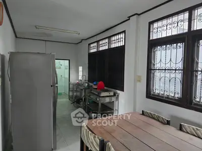 Spacious kitchen with dining area, featuring large windows and ample natural light.