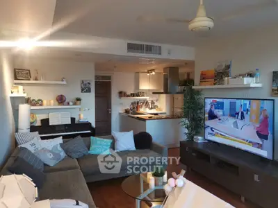 Spacious living room with modern decor and open kitchen layout, featuring a cozy sofa and entertainment area.